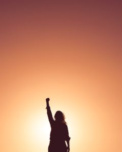 sunset woman fist in air