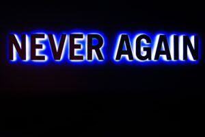 Never again written in black, blue, and white highlights