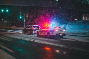 Cop car pulling someone over in a snowstorm
