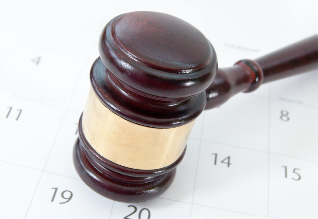 Judge's gavel on top of a page of calendar dates